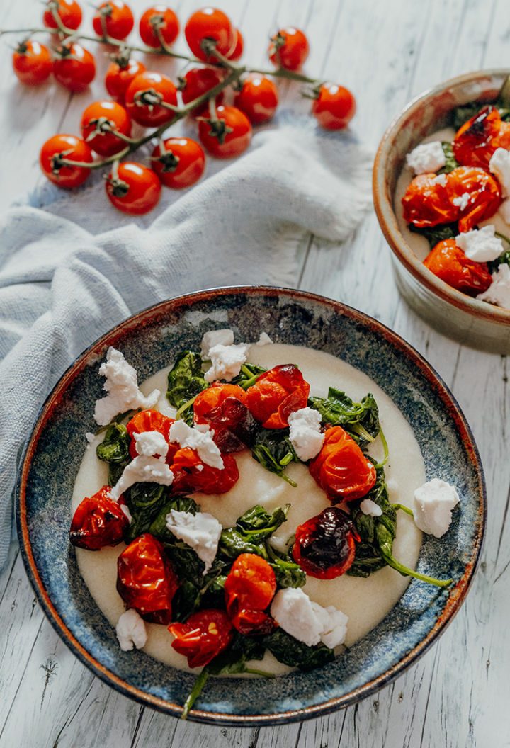 Cremige weiße Ziegenkäse-Polenta mit Tomaten und Spinat